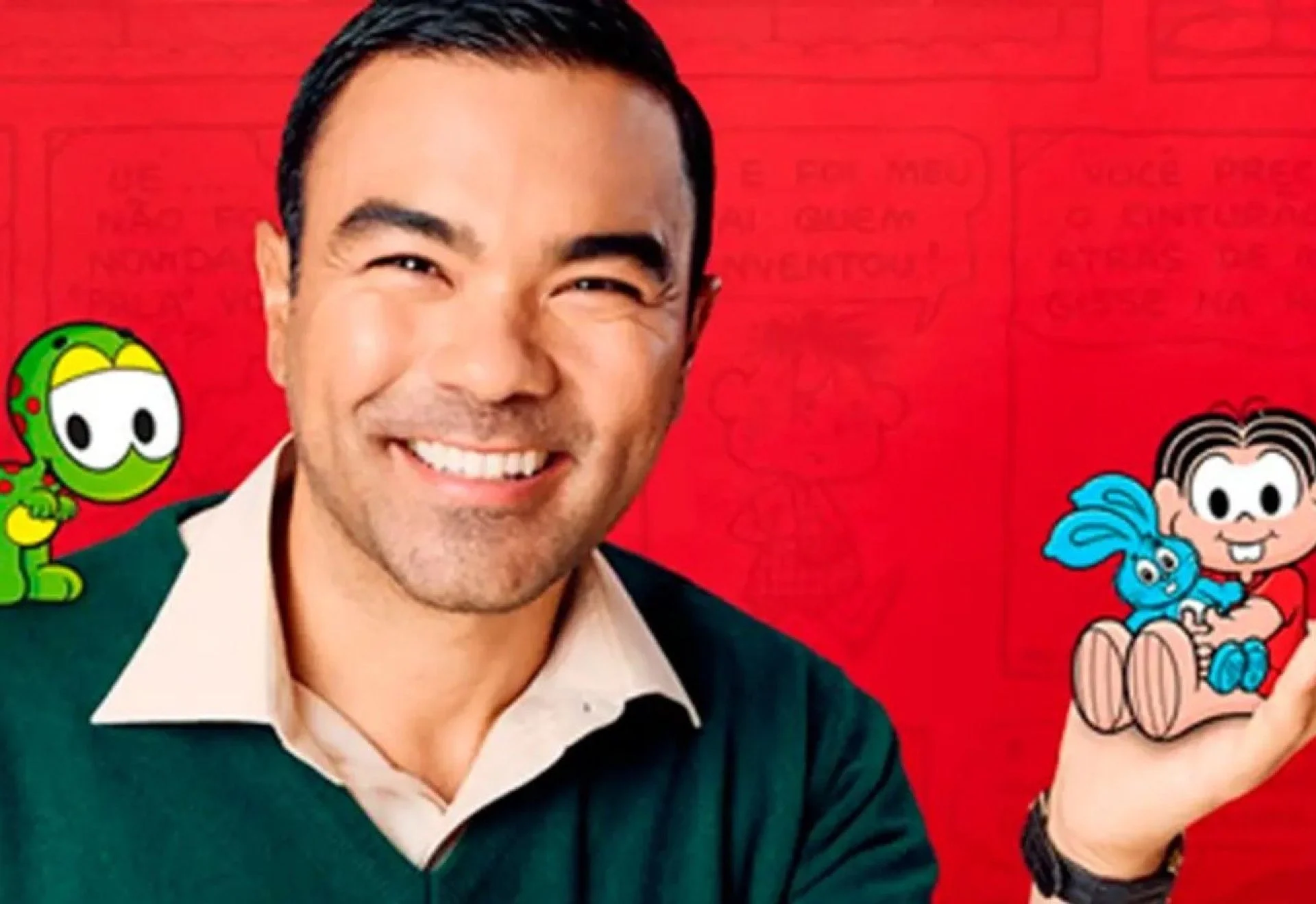 Homem que interpreta Maurício de Sousa sorri. Em suas mãos vemos a personagem Mônica segurando o coelho de pelúcia, Sansão. No ombro vemos o personagem dinossauro, Horácio.